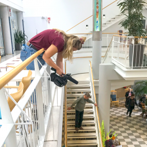 Nuori kuvaa videokameralla parvelta alas päin